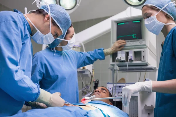 Médicos que operam um paciente — Fotografia de Stock