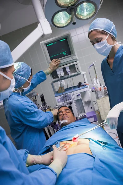 Médicos sérios que operam um paciente — Fotografia de Stock