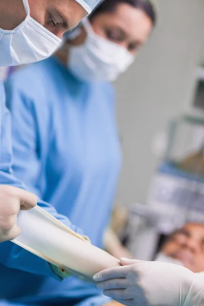 Médico retirando suas luvas durante a operação — Fotografia de Stock