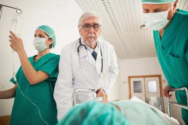 Médico e cirurgião olhando para um paciente — Fotografia de Stock