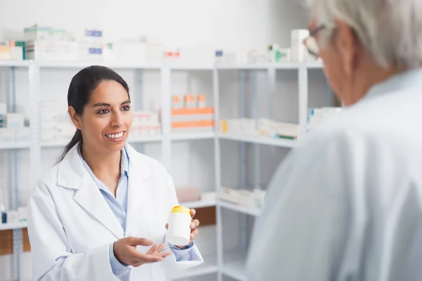 Женщина-фармацевт держит коробку с лекарствами — стоковое фото