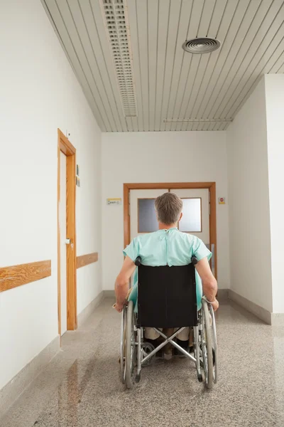 Male patient sitting in a wheelchair in the corridor — Stock Photo, Image