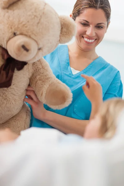 Szczęśliwy pielęgniarka trzyma misia — Zdjęcie stockowe