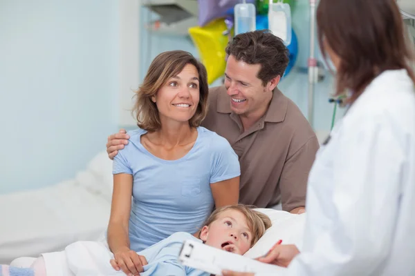 Padres sonrientes junto a un médico —  Fotos de Stock