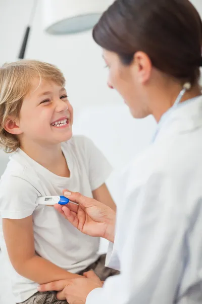 Medico prendendo la temperatura di un bambino — Foto Stock