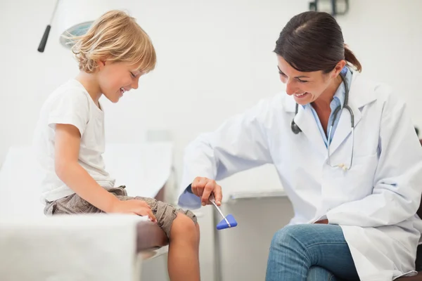 Lekarz badania reakcji nóg dziecka — Zdjęcie stockowe