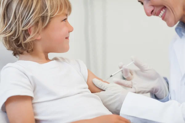 Médico que dá a uma criança uma injeção — Fotografia de Stock