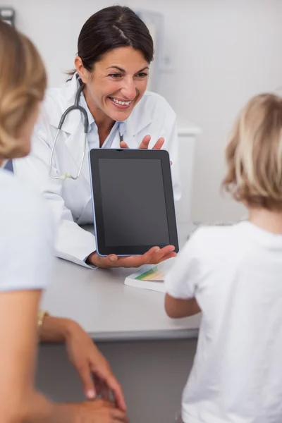 Médico sosteniendo una tableta delante de un niño — Foto de Stock