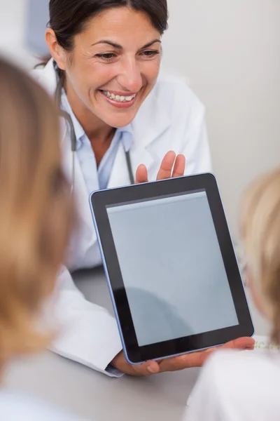 Leende läkare presenterar en tablet PC — Stockfoto