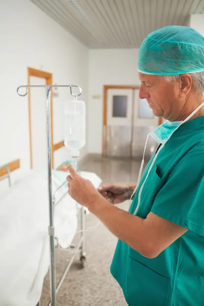 Cirurgião medindo um gotejamento intravenoso — Fotografia de Stock