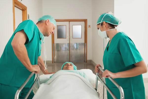 Surgeons leaning on a medical bed — Stock Photo, Image