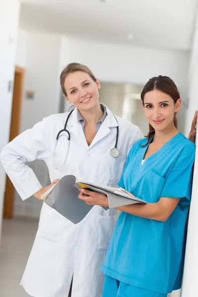 Nurse and a doctor holding a file in a hallway Royalty Free Stock Photos