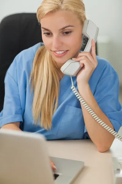 Blond sjuksköterska ringer — Stockfoto