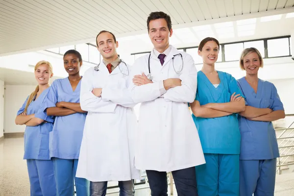 Artsen met verpleegkundigen met gekruiste armen — Stockfoto