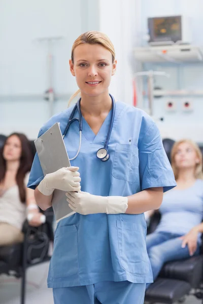 Nurse standing while holding a clipboard — Stock Photo, Image
