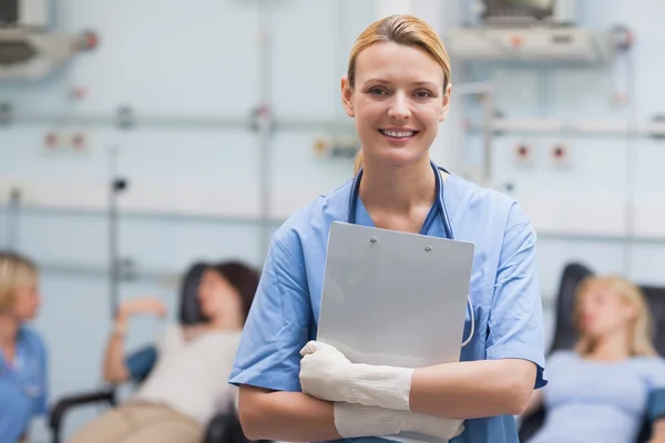 Lächelnde Krankenschwester mit Klemmbrett — Stockfoto