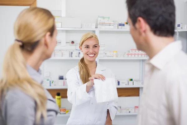 Farmacéutico dando una bolsa de medicamentos a los pacientes — Foto de Stock