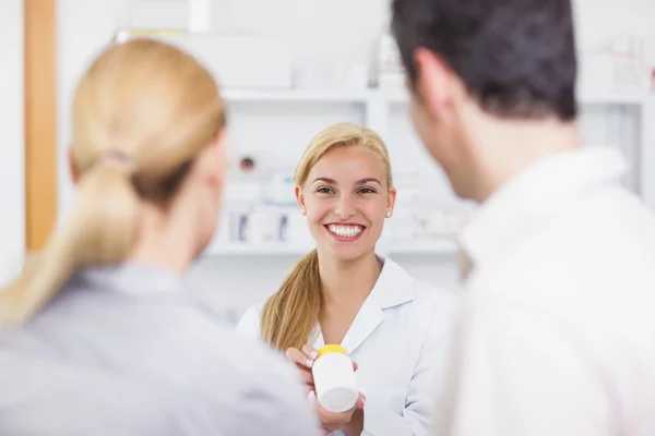 Blonde pharmacist holding a drug box — Stock Photo, Image