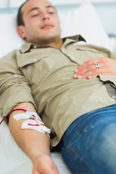Muž transfuzi, ležící na posteli — Stock fotografie