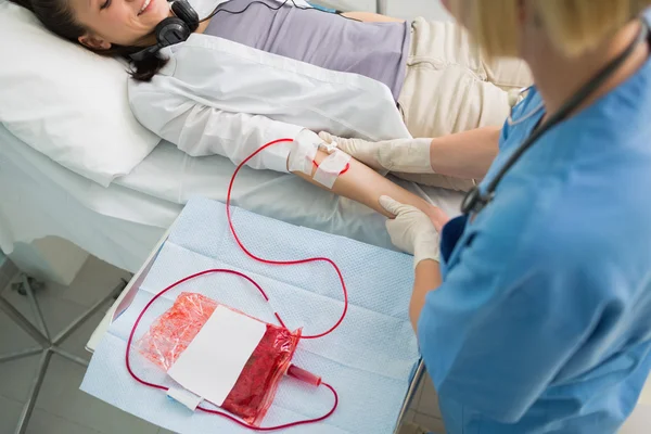 Krankenschwester kümmert sich um transfusionierten Patienten — Stockfoto