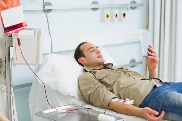 Transfused patient looking at a tablet computer — Stock Photo, Image