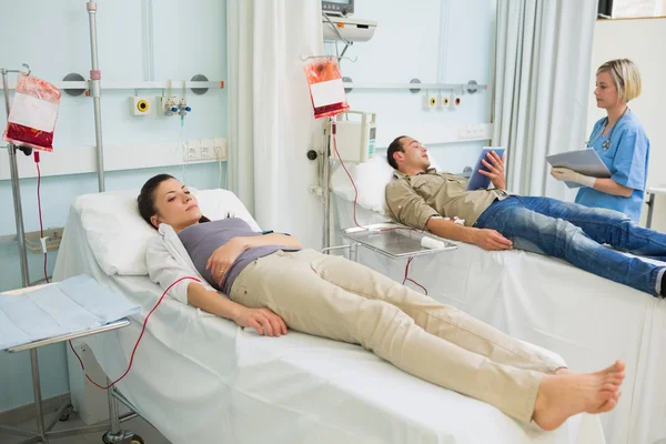 Two transfused patients lying on a medical bed — Stock Photo, Image