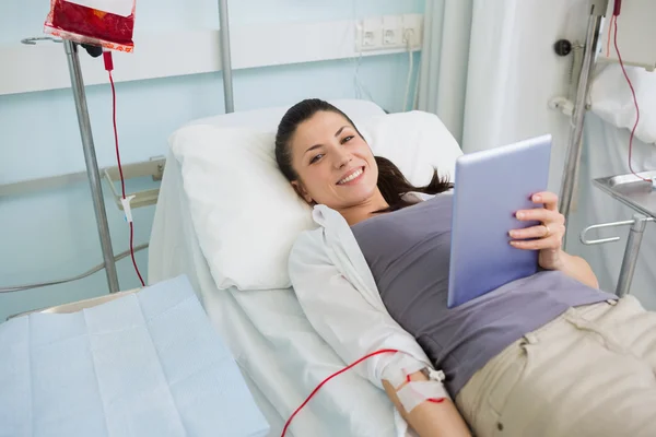 輸血を保持しているタブレット コンピューター笑みを浮かべてください。 — ストック写真