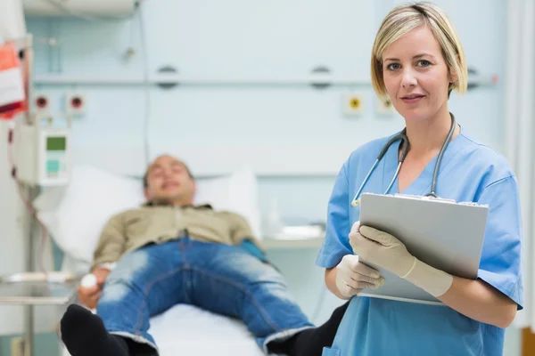 Krankenschwester neben einem männlichen Patienten — Stockfoto