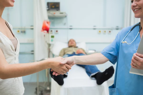 Enfermeira apertando a mão de um paciente — Fotografia de Stock