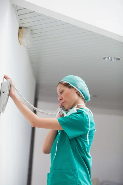 Cirurgiã feminina segurando um telefone — Fotografia de Stock