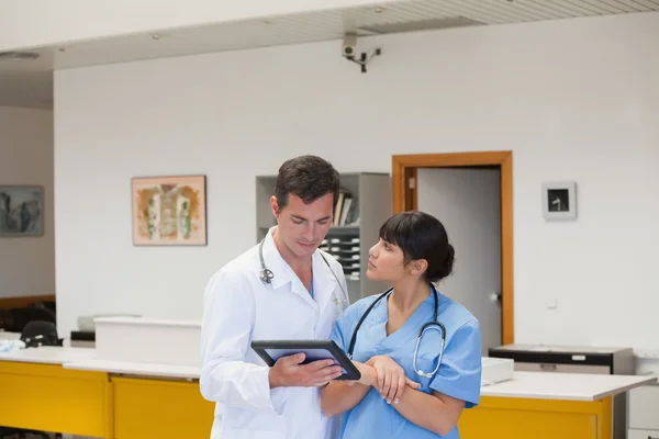 Lekarz posiadający komputer typu tablet obok pielęgniarka — Zdjęcie stockowe