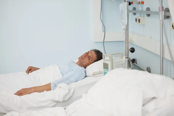 Paciente varón acostado en una cama médica —  Fotos de Stock