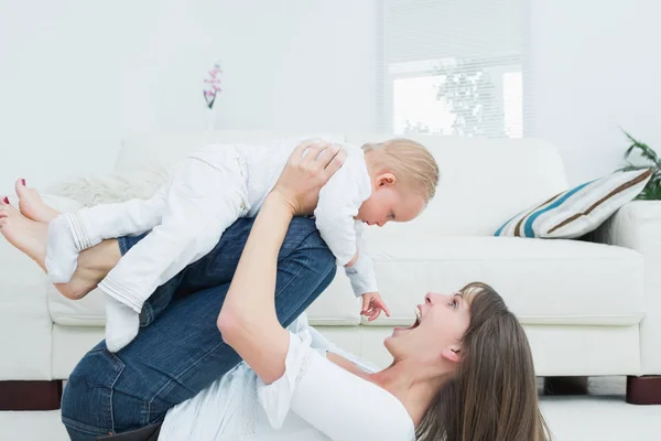 Mãe deitada brincando com um bebê — Fotografia de Stock