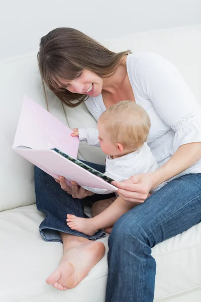 Bebê segurando um livro com uma mãe — Fotografia de Stock