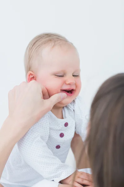 Mãe tocando a bochecha de um bebê — Fotografia de Stock