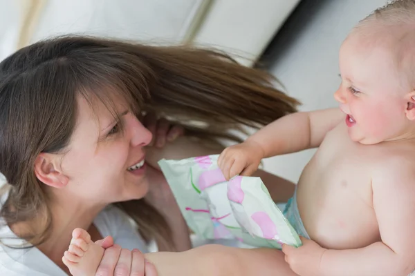 Bebê deitado de costas enquanto segurava brinquedo — Fotografia de Stock