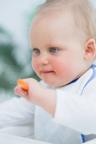 Baby hält einen Plastiklöffel — Stockfoto