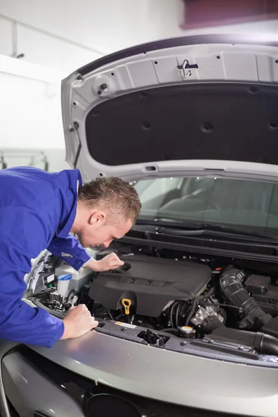 Mechanik hledá uvnitř motoru automobilu — Stock fotografie