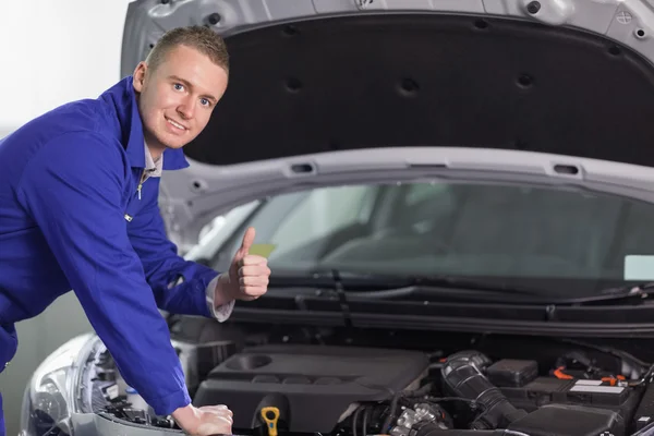 Mechaniker blickt mit erhobenem Daumen in die Kamera — Stockfoto