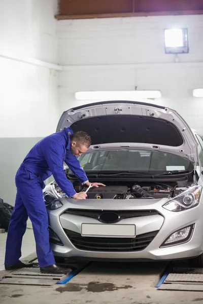 Mechanic looking at the car engine — Stock Photo, Image