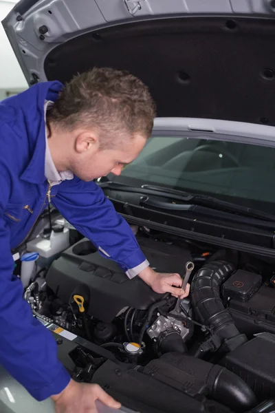 Mecânico de reparação de um motor com uma chave — Fotografia de Stock