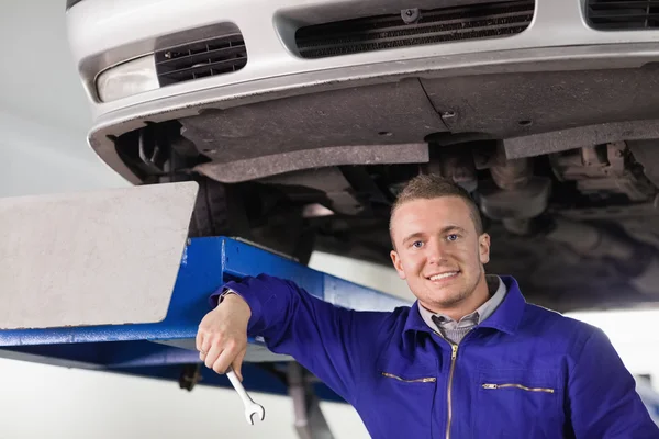Mekaniker innehar en käpp under en bil — Stockfoto