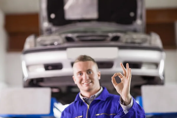 Lächelnder Mechaniker macht eine Geste mit den Fingern — Stockfoto