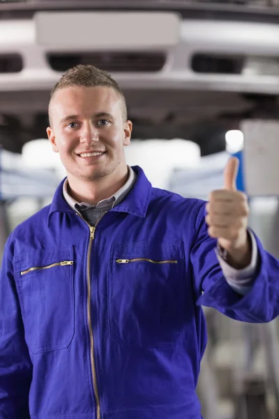 Mechaniker steht mit erhobenem Daumen neben einem Auto — Stockfoto