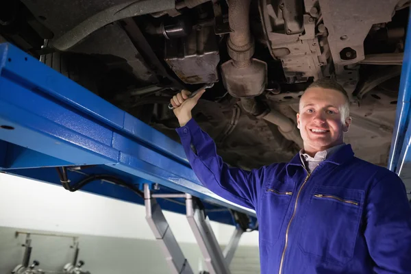 Smiling mechanic repairing with a spanner — Stock Photo, Image