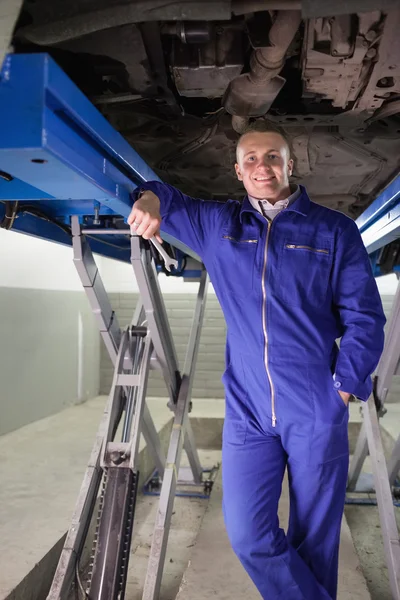 Mechanic leunend op een machine terwijl een spanner — Stockfoto