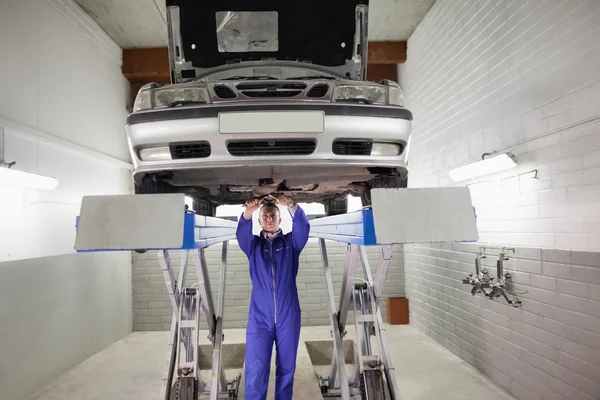 Mechanic standing while repairing a car with tools — Stock Photo, Image