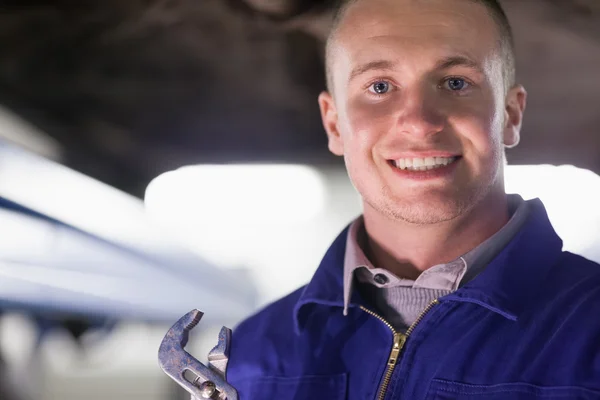 Mechanic holding an adjustable pliers while looking at camera — Stock Photo, Image