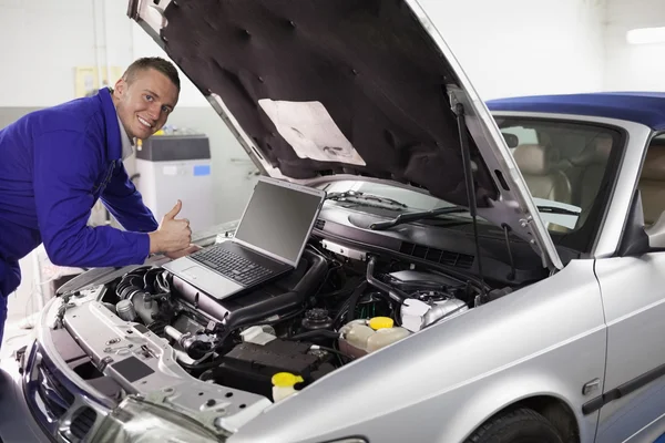 Mechaniker stützt sich auf einen Automotor — Stockfoto