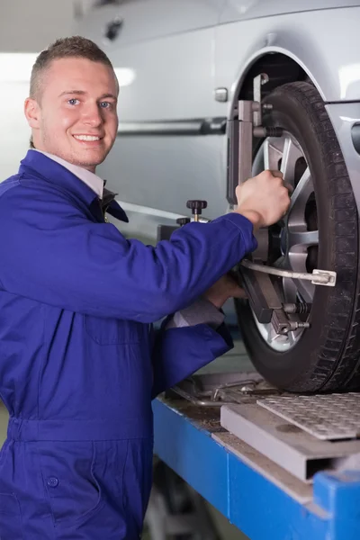 Mechanic wijzigen van een auto wiel lachende — Stockfoto